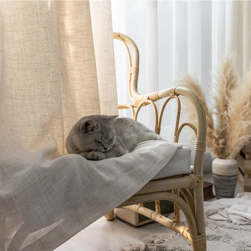 Natural linen sheer curtains filtering sunlight in a cozy bedroom